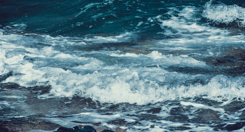 High angle view of waves reaching on shore at beach