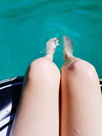 Low section of woman relaxing in swimming pool