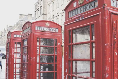 Red telephone booth on building in city