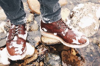 Mans feet in boots covered with snow