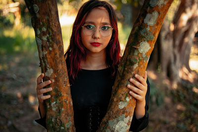 Portrait of teenager girl with pierced lips by tree