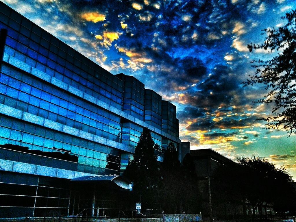 architecture, building exterior, built structure, sky, low angle view, cloud - sky, building, cloudy, cloud, city, residential building, residential structure, window, glass - material, sunset, tree, outdoors, no people, modern, house