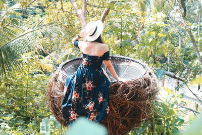 Rear view of woman standing by tree