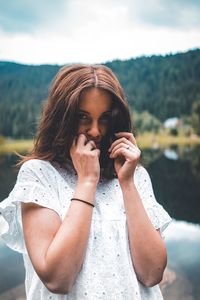 Portrait of beautiful woman standing against blurred background