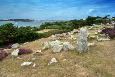 Rocks on sea shore against sky