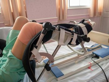 Low section of injured woman on bed in hospital