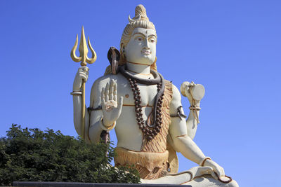 Low angle view of statue against blue sky