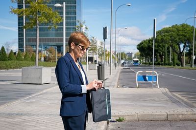 A businesswoman requests a car through her mobile at the financial district