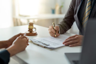 Midsection of lawyer working at desk in office