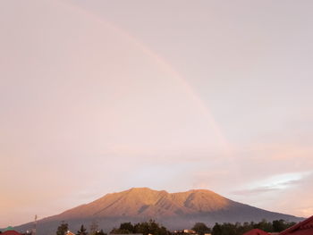 Scenic view of rainbow over mountains against sky