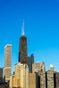 Low angle view of skyscrapers against blue sky