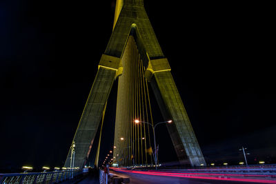 Low angle view of illuminated bridge against sky at night