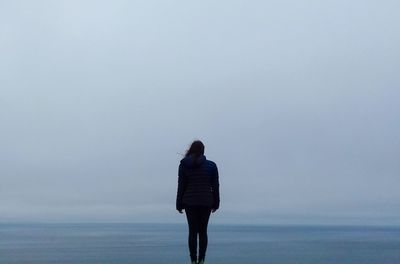 Rear view of woman looking at sea against clear sky