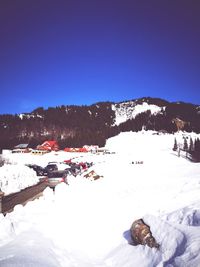 Scenic view of snow covered mountains against clear blue sky