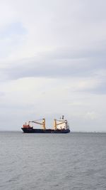 Ship sailing on sea against sky