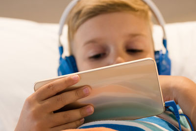 Close-up of boy using mobile phone at home