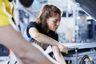 Side view of young woman exercising in gym