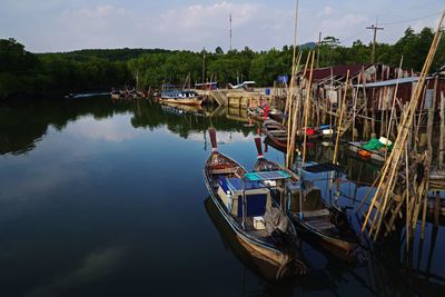 Boats moored at harbor against sky