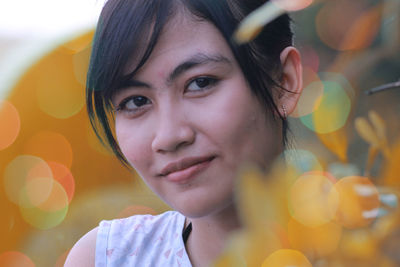 Close-up portrait of smiling young woman in park