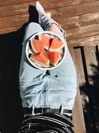 Low section of woman with watermelon in plate