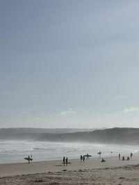 People at beach against sky