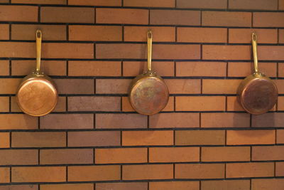 Close-up of metal hanging against brick wall