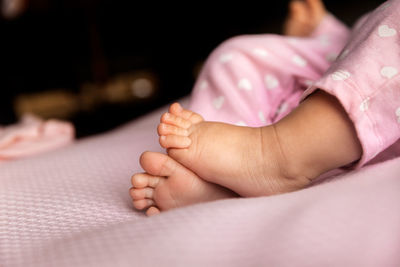 Low section of baby on bed
