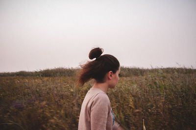 Woman standing on field against clear sky