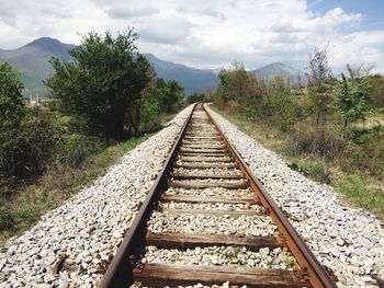 Railway tracks on landscape against sky