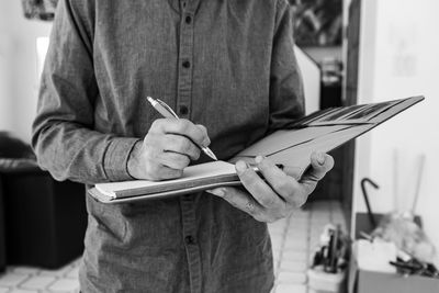 Midsection of man reading book