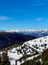 Scenic view of snowcapped mountains against blue sky