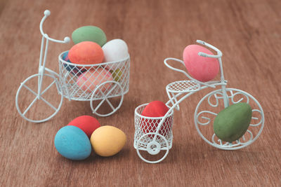 Close-up of colorful easter eggs with miniature bicycle toy on wooden table