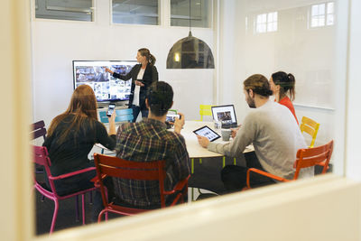 Businesswoman giving presentation during conference call in board room of creative office