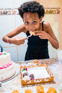 Portrait of girl eating sweet food at home