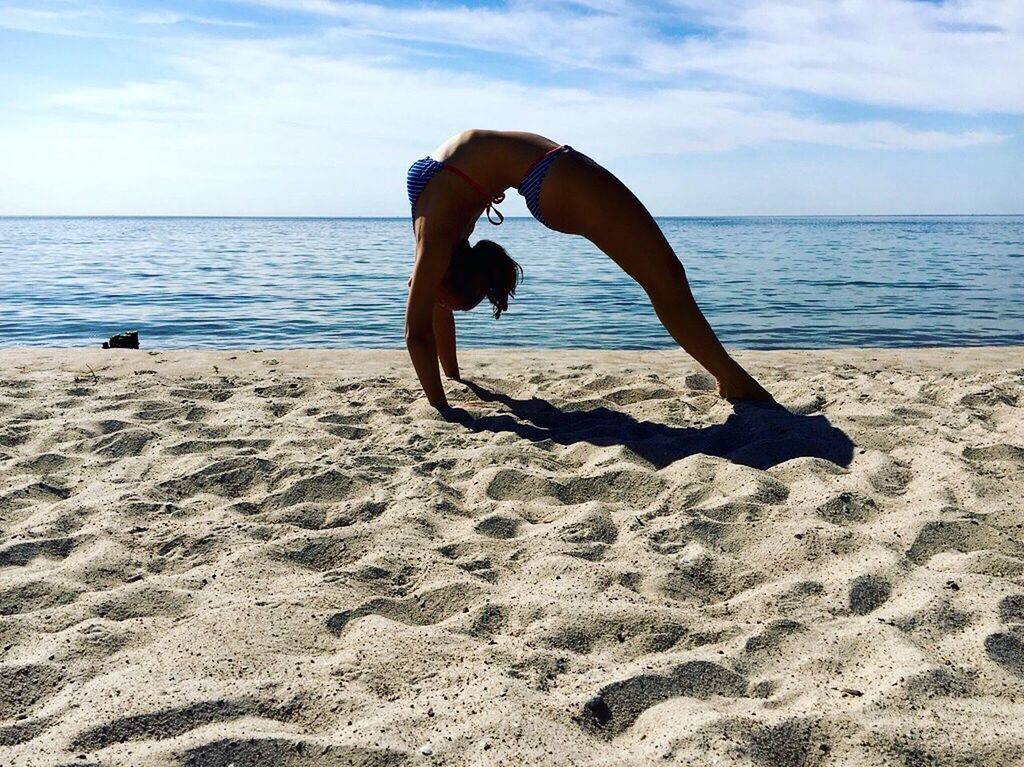 sea, beach, water, sky, leisure activity, full length, shore, horizon over water, lifestyles, vacations, enjoyment, tranquil scene, jumping, mid-air, wave, beauty in nature, arms outstretched, scenics, cloud - sky, tranquility, nature, freedom, fun, idyllic, cloud, tourist, balance