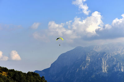 Low angle view of person paragliding against sky