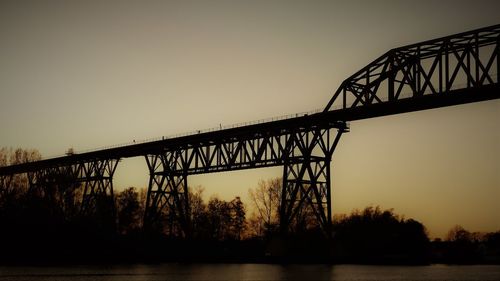 Low angle view of silhouette bridge against sky during sunset