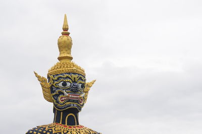 Low angle view of statue against temple building against sky