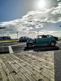 Cars on street in city against sky