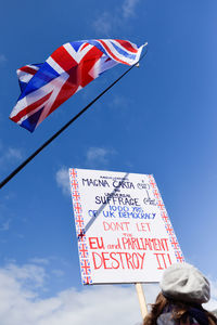 Low angle view of flag against blue sky