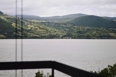 Scenic view of lake by mountains against sky