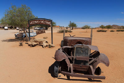 View of abandoned bus on desert against clear sky