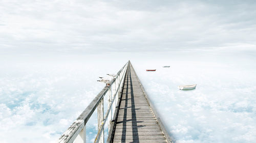 Digital composite image of pier and cloudy sky