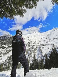 Rear view of woman on snowcapped mountain against sky