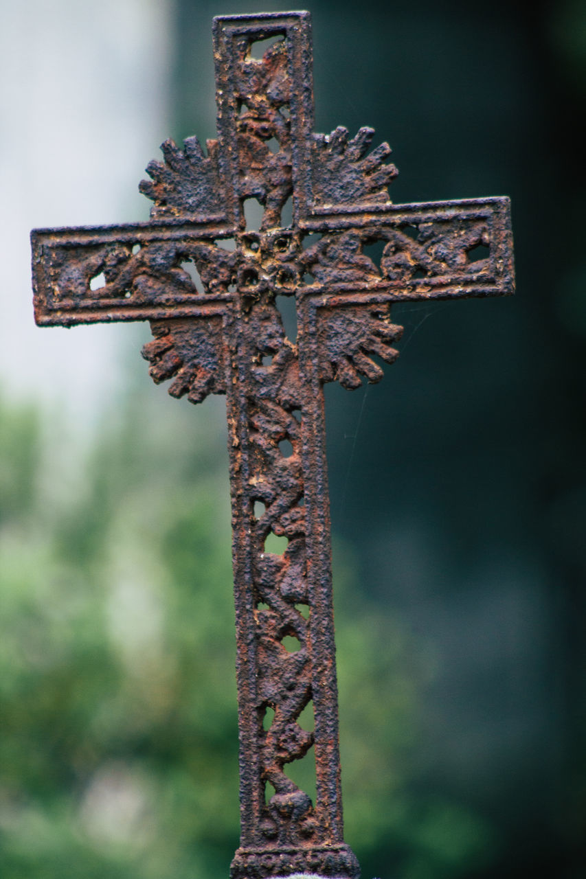 LOW ANGLE VIEW OF CROSS ON RUSTY METAL AT CEMETERY