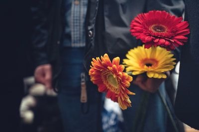 Midsection of man holding flowers