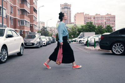 Two young women with shopping bags walking in the city