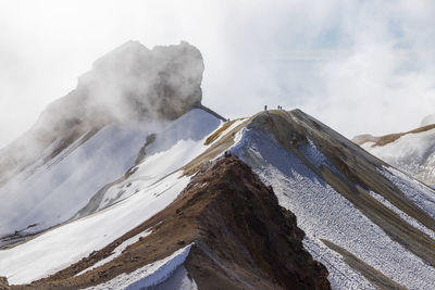 Scenic view of snowcapped mountains ridge against sky