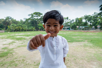 Portrait of smiling boy standing on field