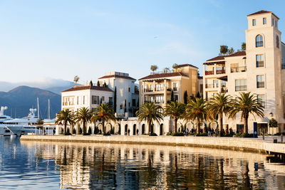 Buildings by river against clear sky